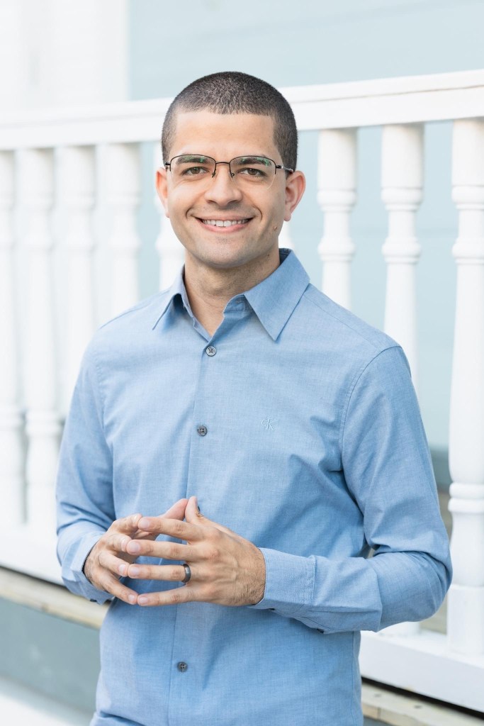 El representante por acumulación y portavoz del partido Movimiento Victoria Ciudadana, José Bernardo Márquez. Viste una camisa de botones azul, está frente a una pared blanca