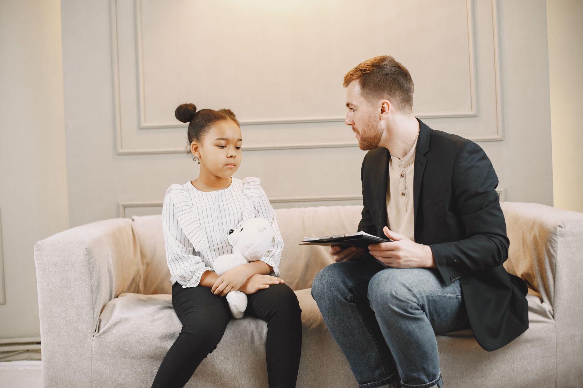 man in black blazer talking to a child